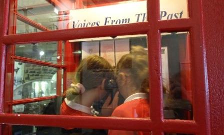 Two children learning how an old sale phone box operated